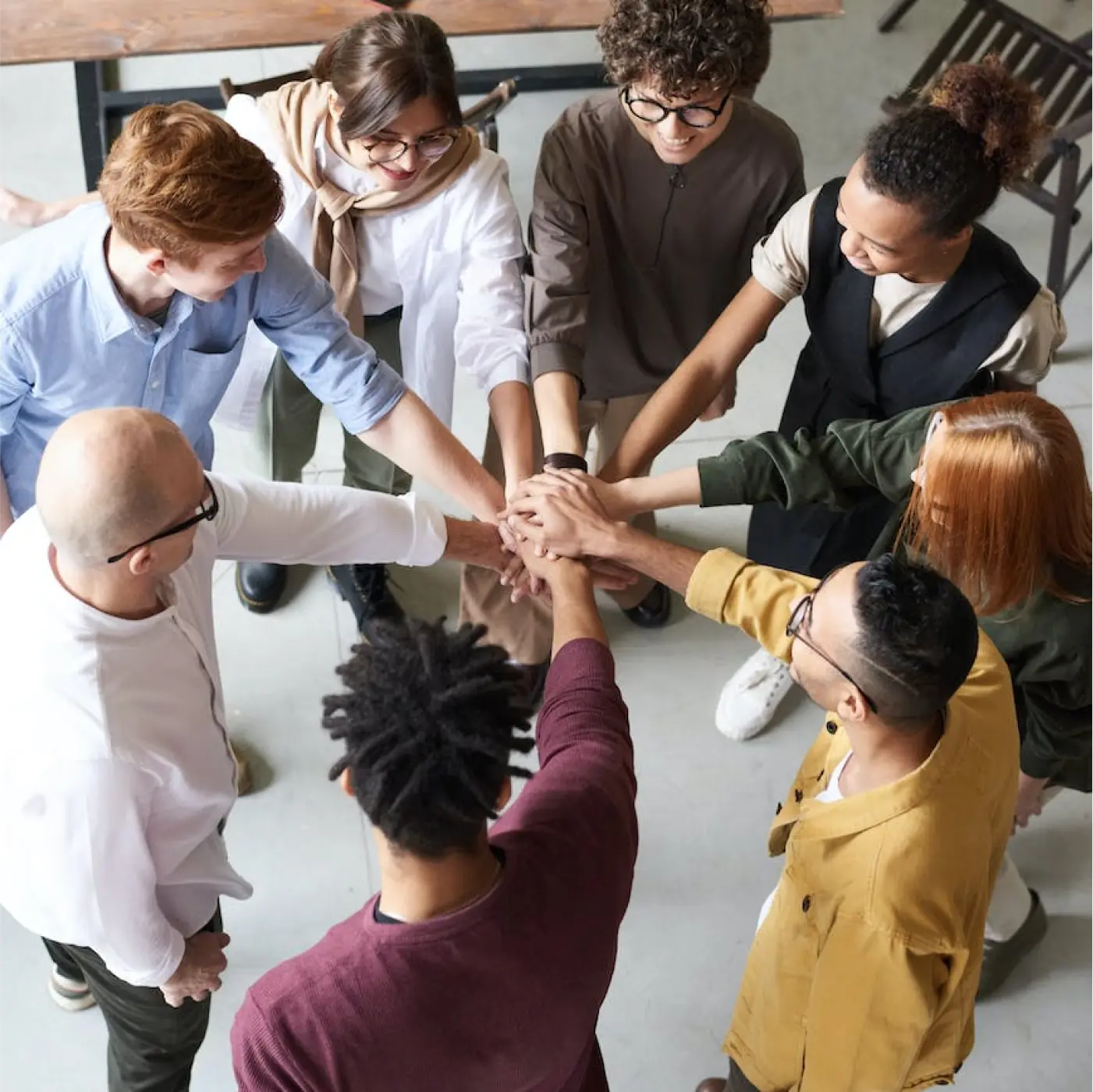 People gathering around, hands together in the middle