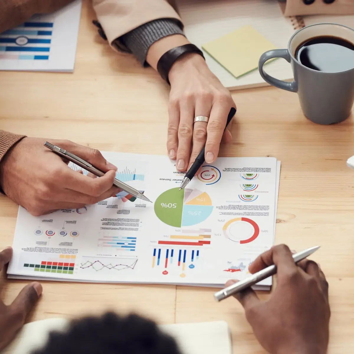 People pointing at a graph on the table