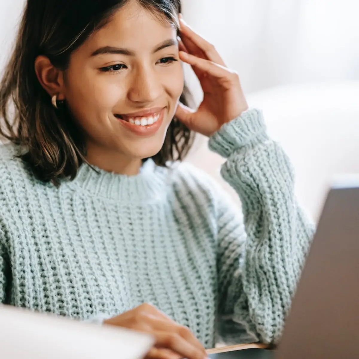 A women smiling infront of her laptop