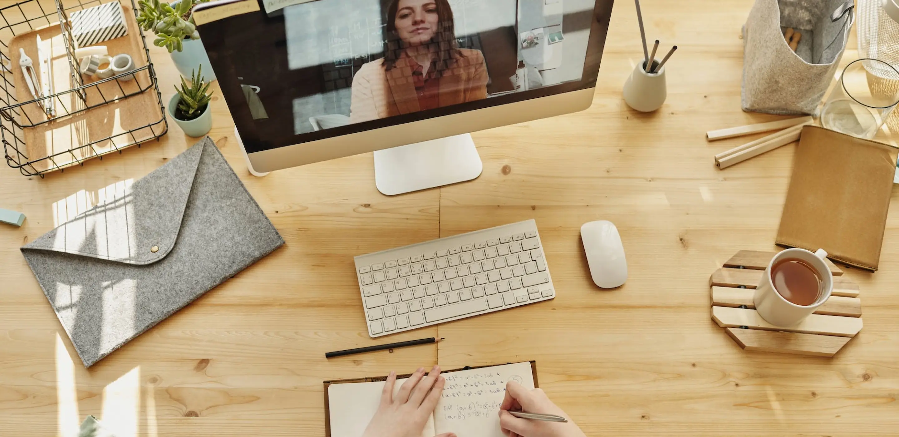 An all in one computer with keyboard and coffee on top of wooden table